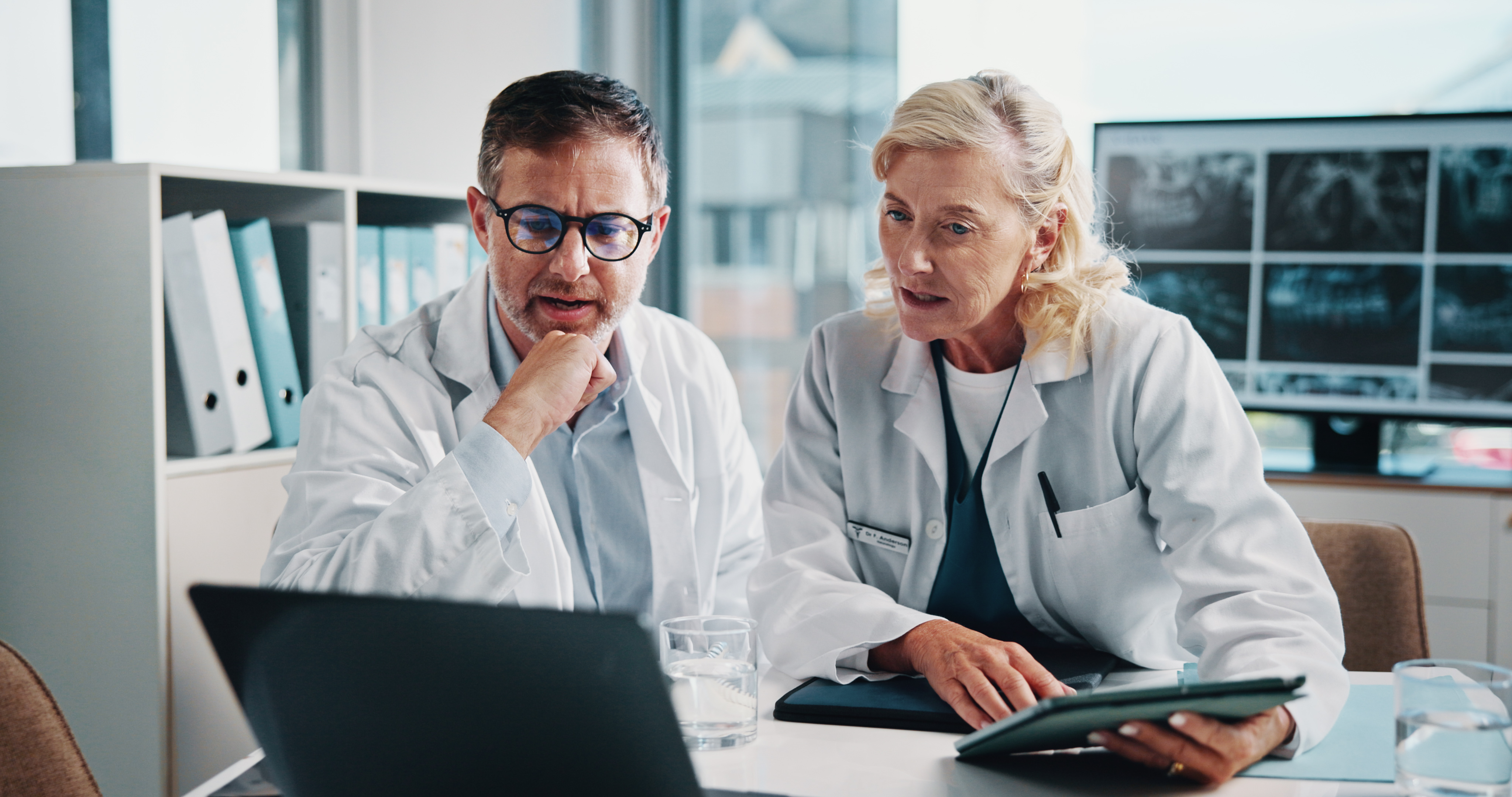People, doctors and meeting on laptop at hospital for x ray study, laboratory results and collaboration. Staff, tablet and online information for radiology, problem solving and medical report of scan