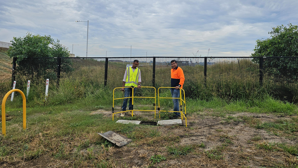 Picture of two Vocus workers in high vis working on a pit at Western Sydney Airport