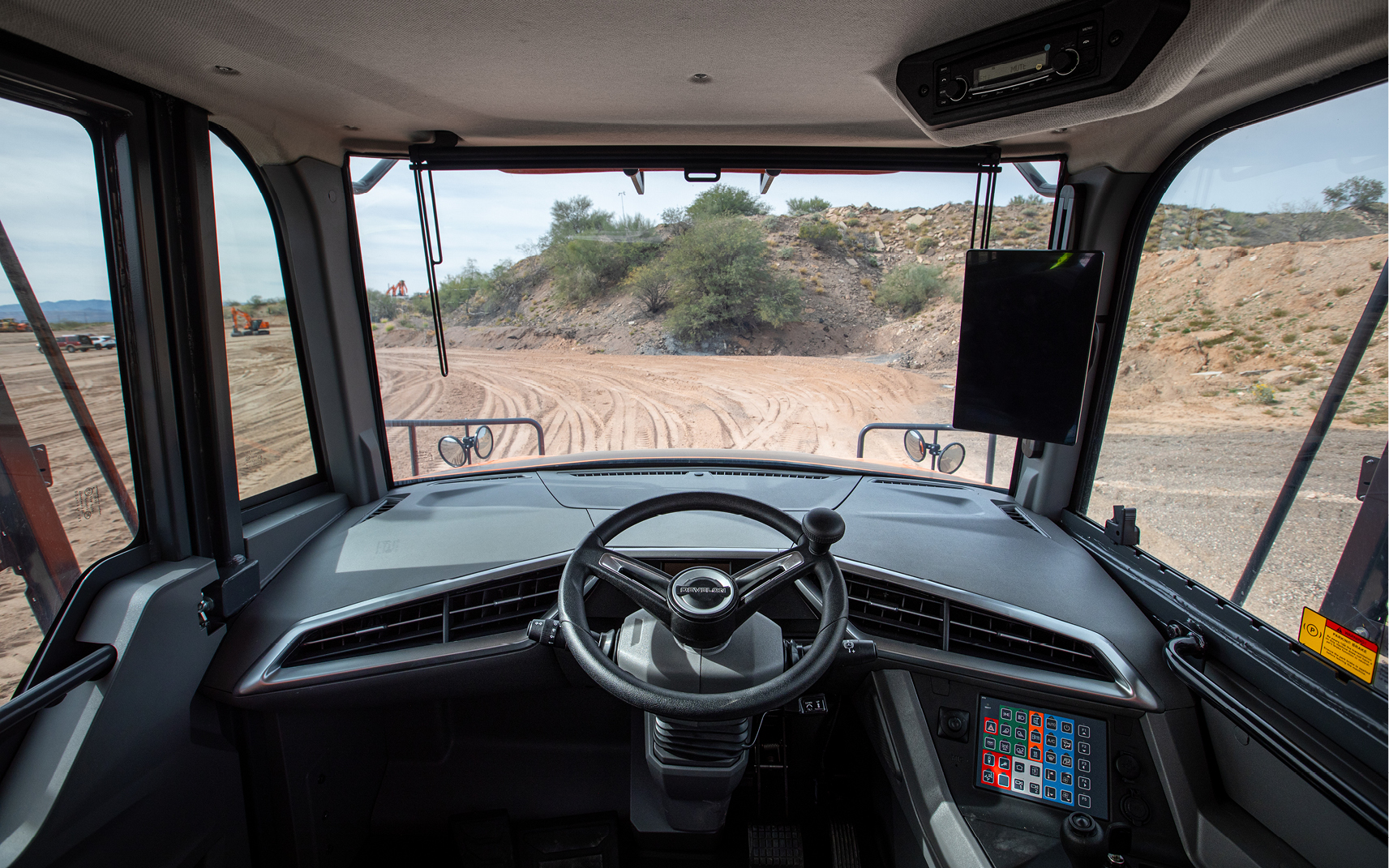 An operator’s view from inside the cab of a DEVELON articulated dump truck.