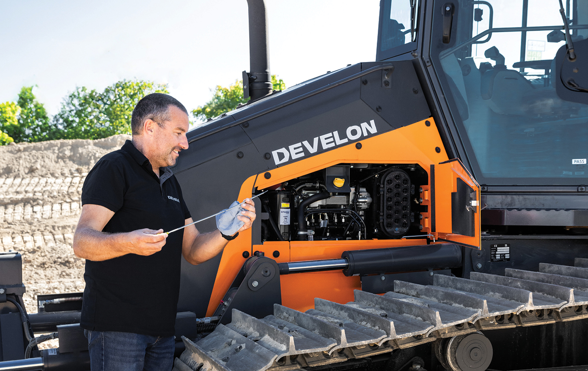 Equipment owner checks the oil while doing preventive maintenance on a DEVELON dozer.