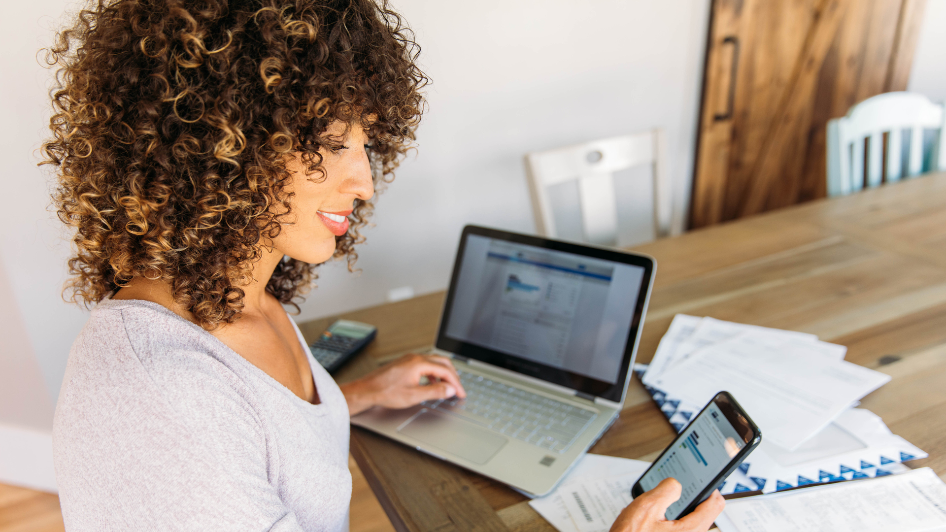 Woman Doing Finances at Home on Smart Phone