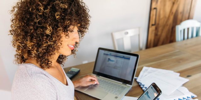 Woman Doing Finances at Home on Smart Phone