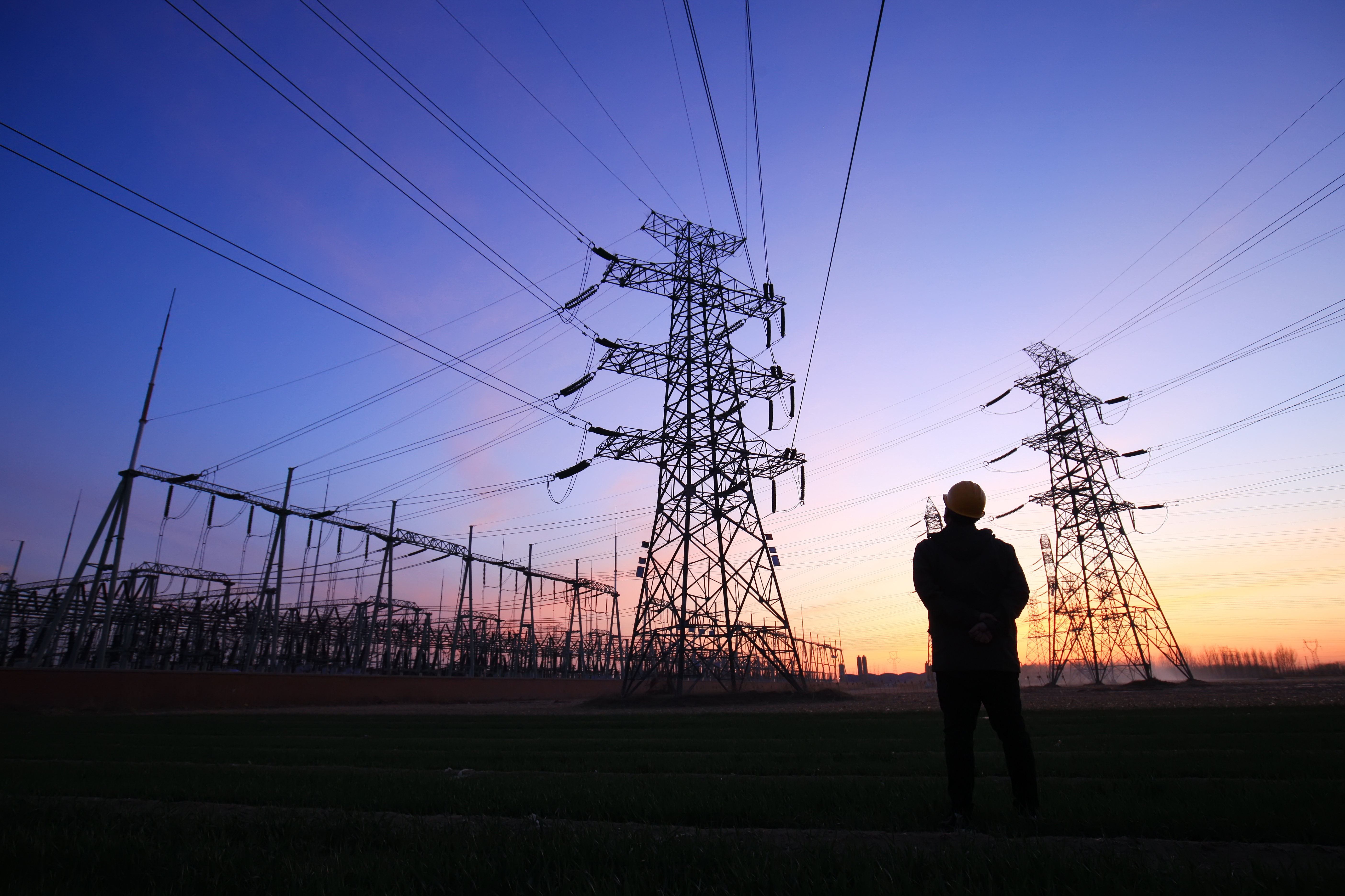 A field service technician at an energy plant at sunset.