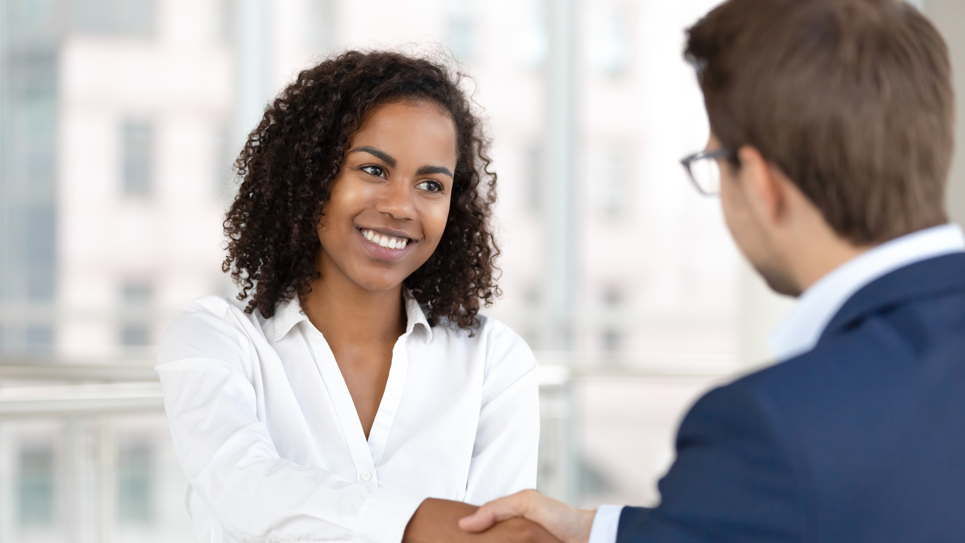 Smiling african hr manager handshake hire candidate at job interview