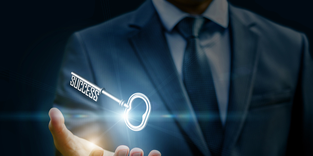 Businesswoman showing a key in his hand.