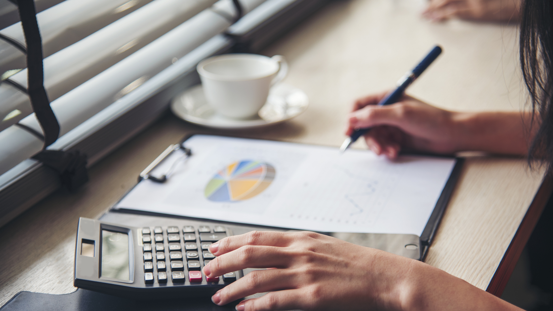 Woman Hands working home do accounting small business. Audit Businesswoman at office desk. Close up businesswoman hands audit accountant using calculator, business graph chart working at home office.