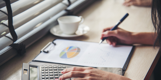 Woman Hands working home do accounting small business. Audit Businesswoman at office desk. Close up businesswoman hands audit accountant using calculator, business graph chart working at home office.