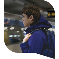 A boy stares off into the distance at a train station