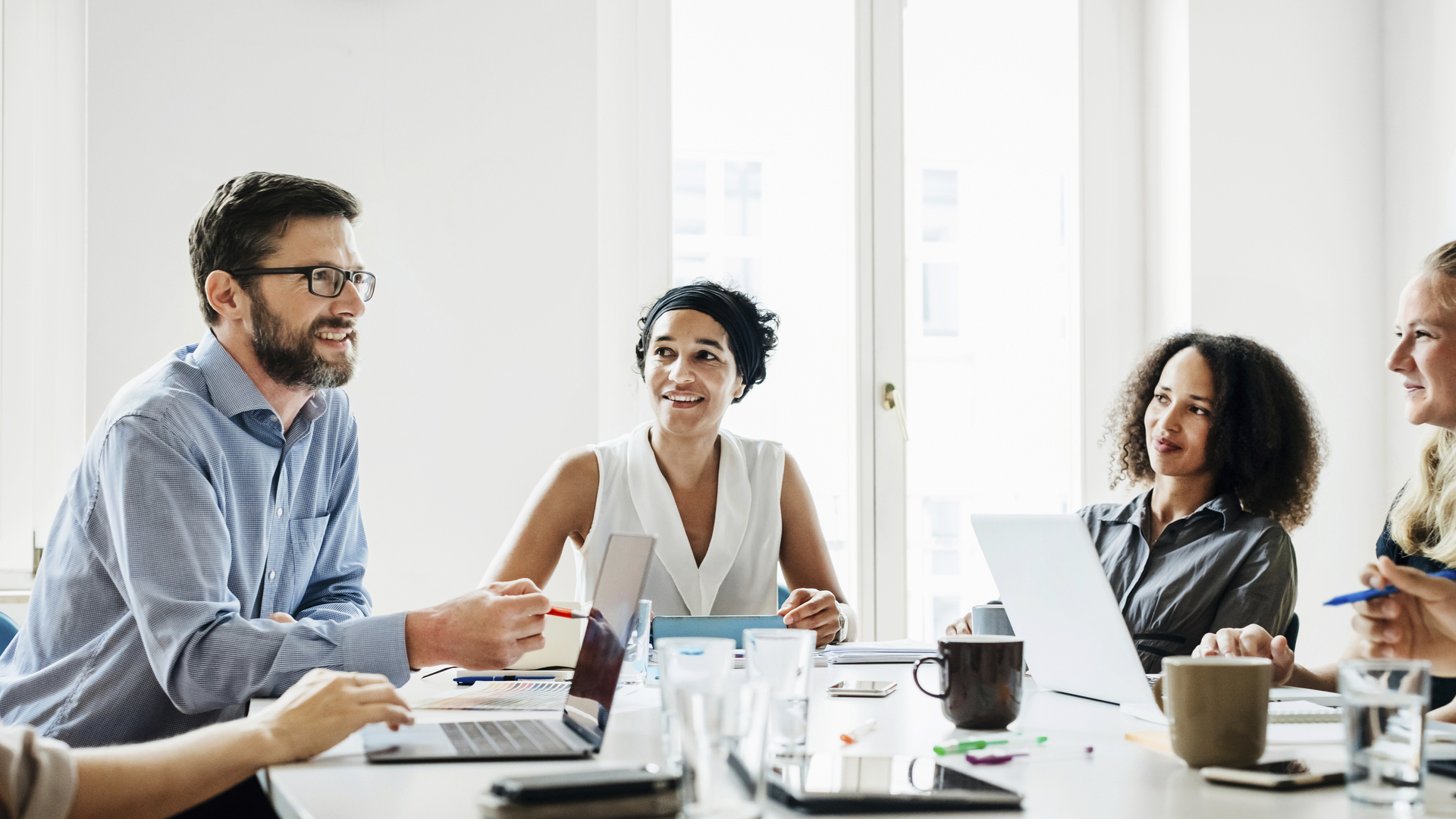 Office Manager Talking To Employees During Morning Meeting