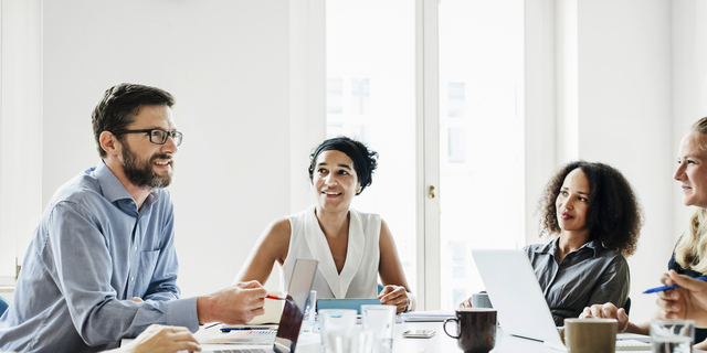 Office Manager Talking To Employees During Morning Meeting