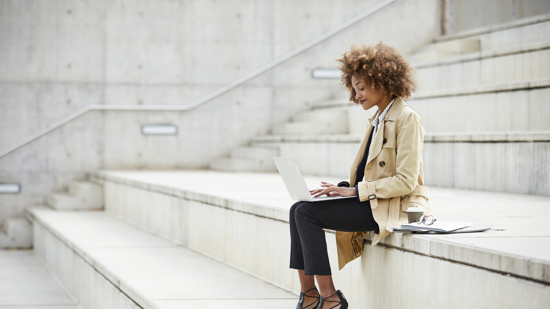 Businesswoman using laptop while sitting on steps