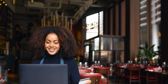 Portrait of restaurant owner using laptop