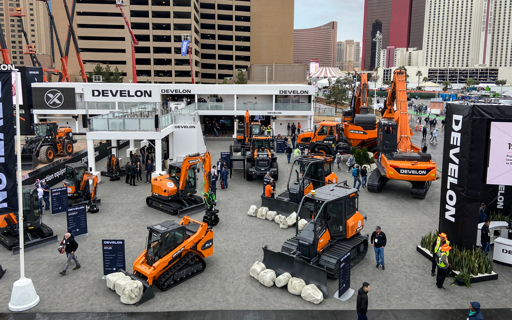 DEVELON equipment showcased at an outdoor booth at CONEXPO 2024.