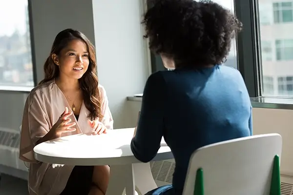 Two women seated at table having a conversation