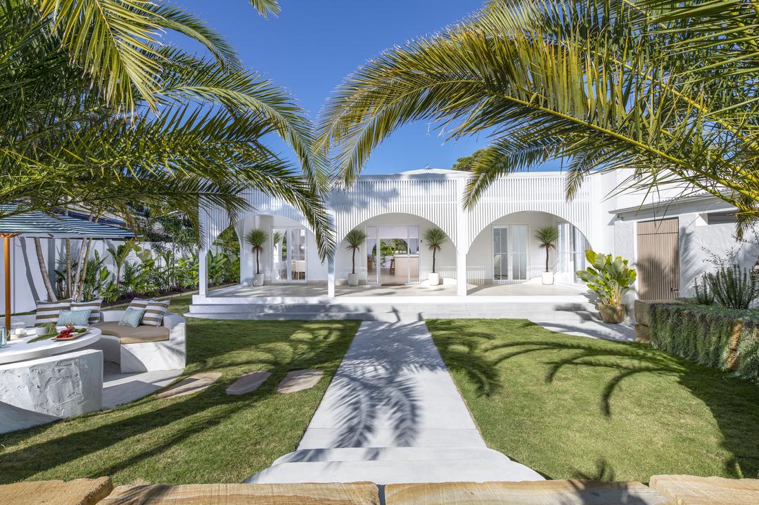 Front of house showing garden path, lawns, multiple arched entry and 2 large palm trees 