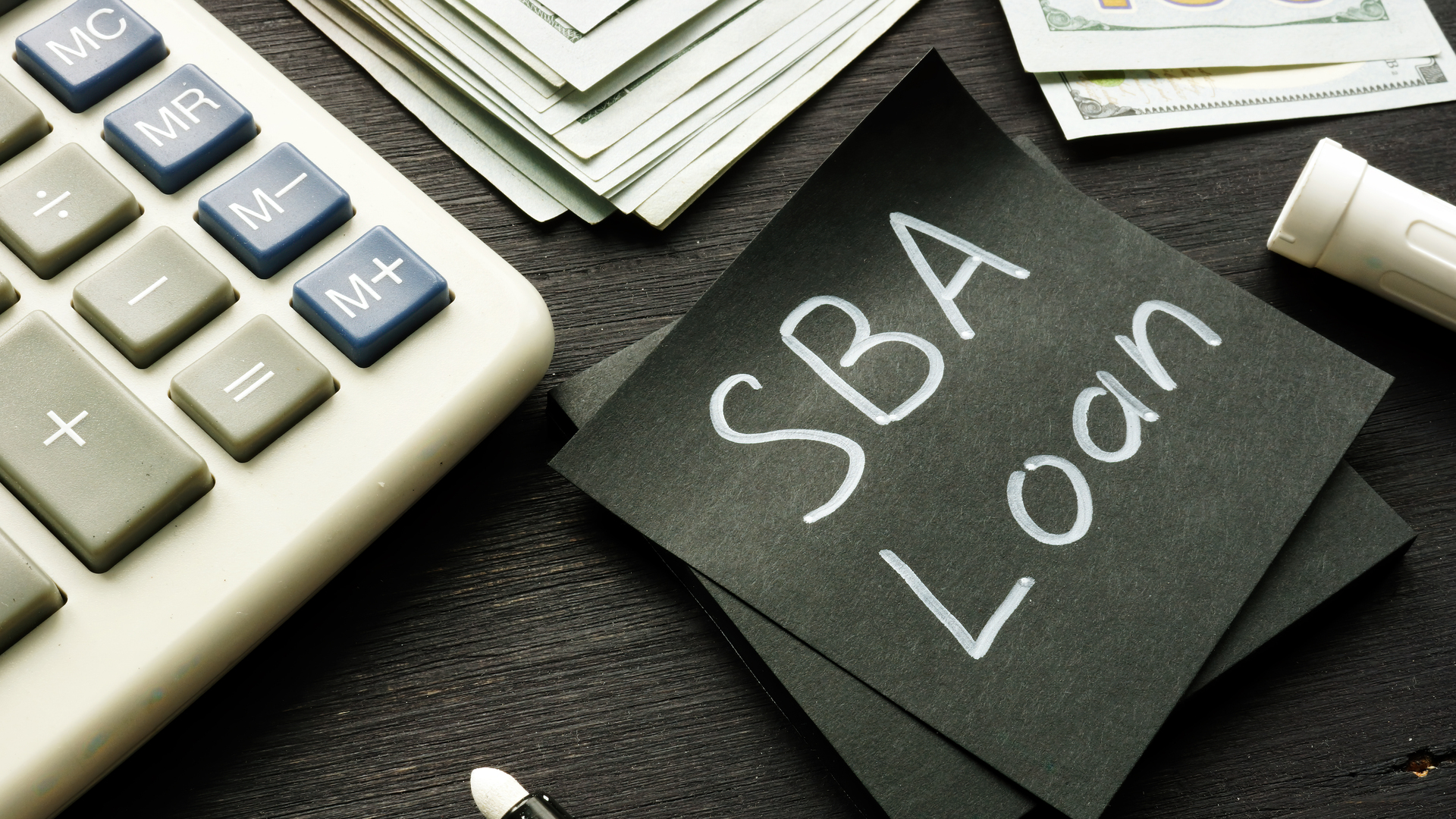 SBA loan handwritten memo on the calculator.