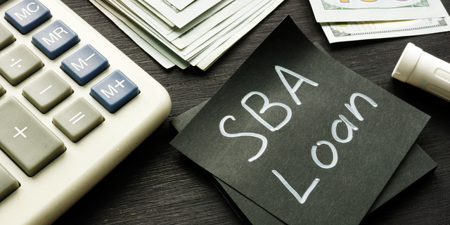 SBA loan handwritten memo on the calculator.
