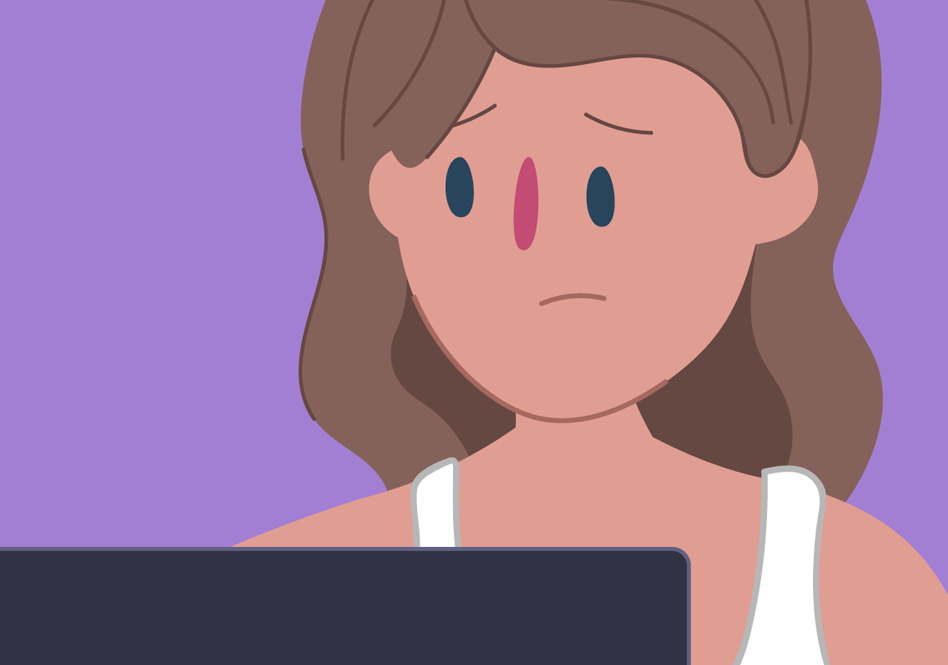 A young girl sitting in front of a laptop and looking worried.