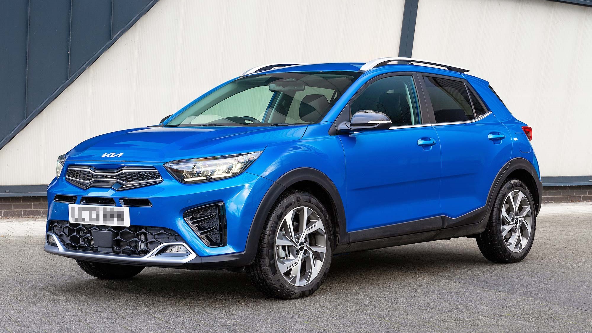 Bright blue Kia Stonic parked by a building