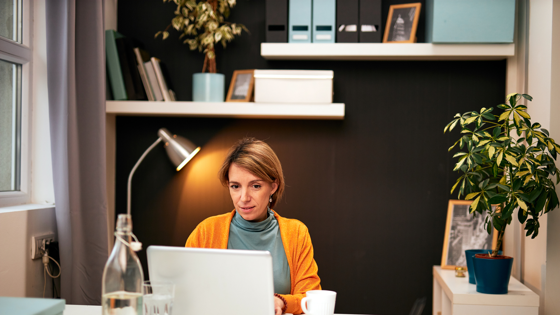 Portrait of smiling Caucasian businesswoman sitting in home office working. Work from home concept.