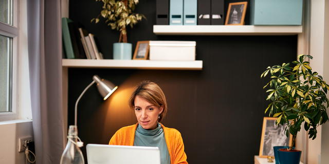 Portrait of smiling Caucasian businesswoman sitting in home office working. Work from home concept.