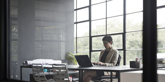 Entrepreneur typing over laptop in modern office