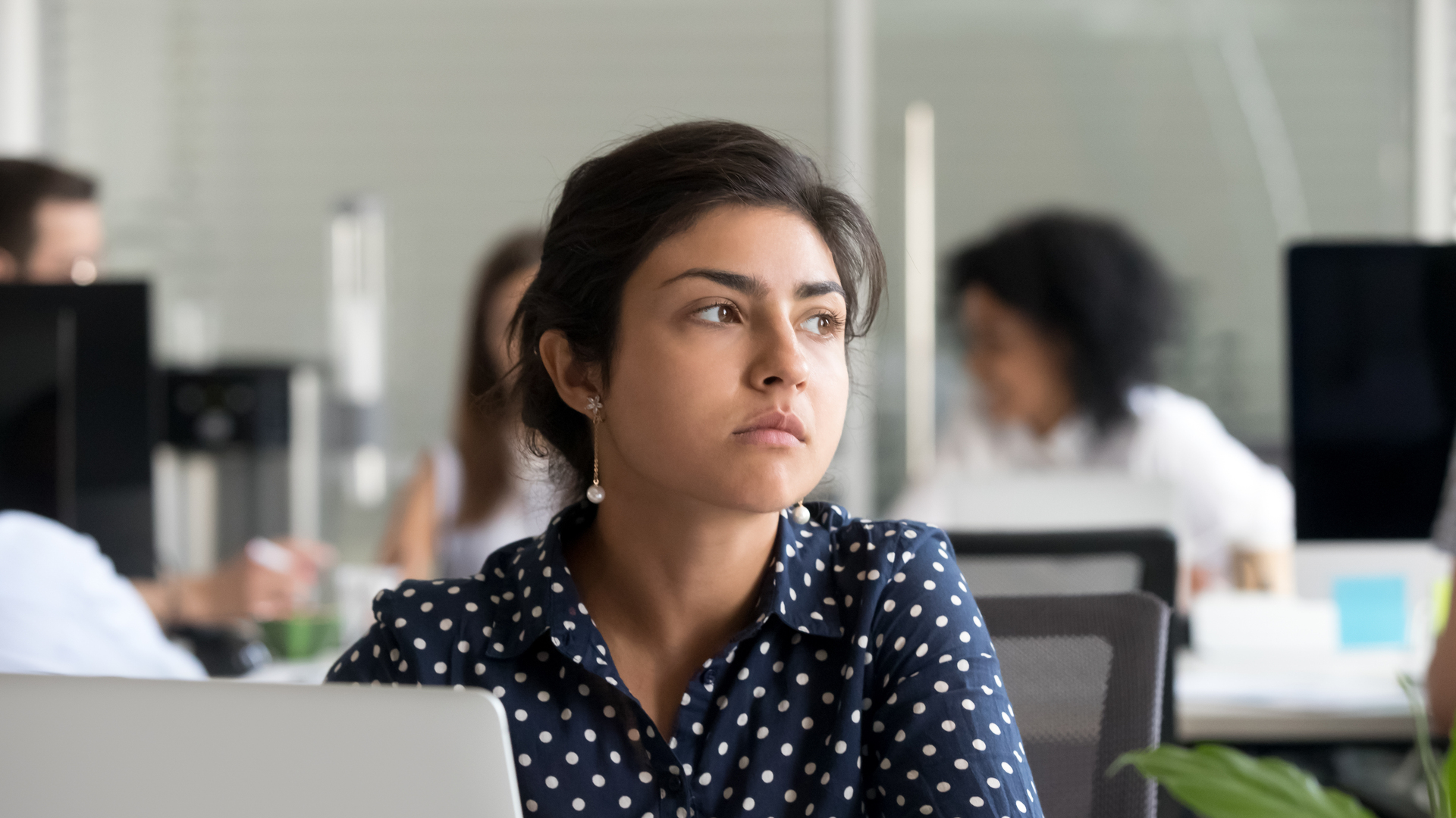 Thoughtful indian businesswoman looking away thinking of problem solution