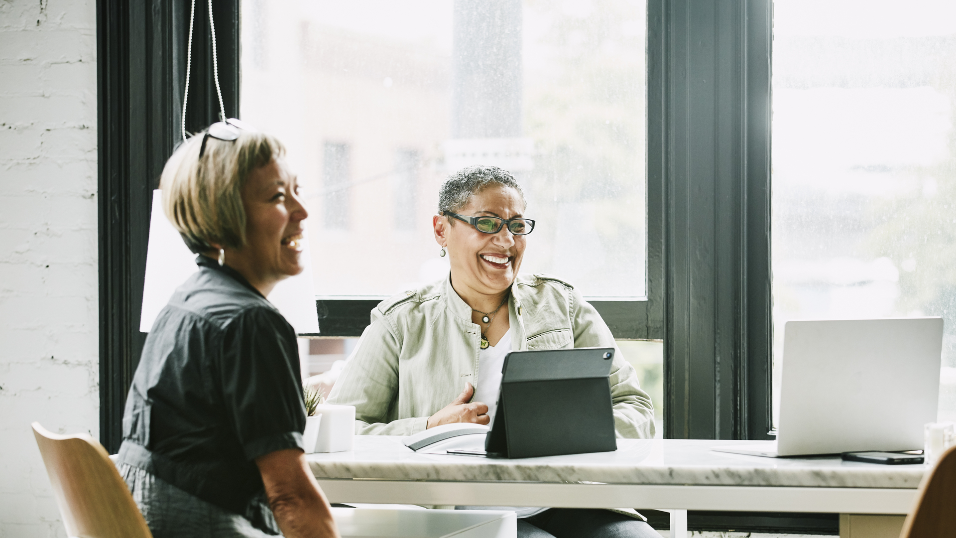 Laughing mature female business partners in meeting in office