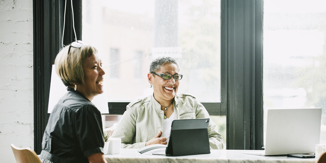 Laughing mature female business partners in meeting in office