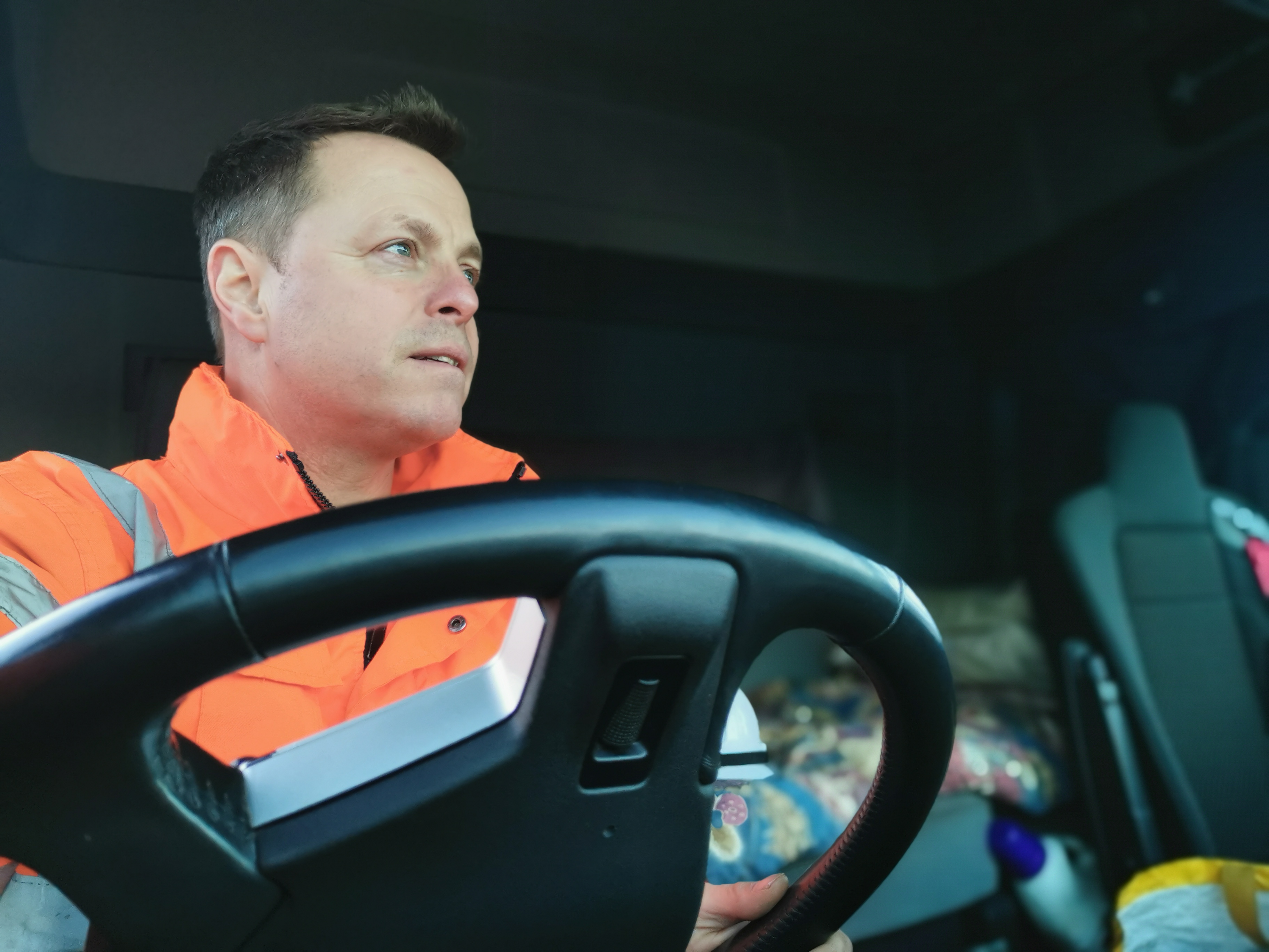 A field service technician in his vehicle uses fleet optimization tools on the road.