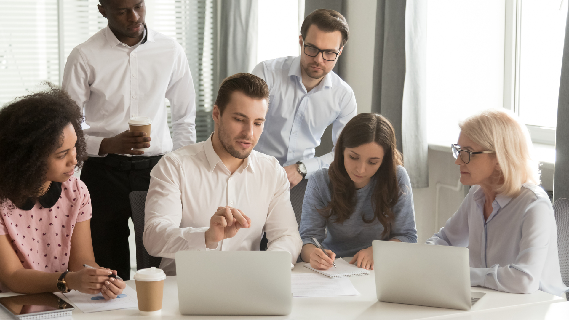 Company employees listening boss sitting at desk in boardroom