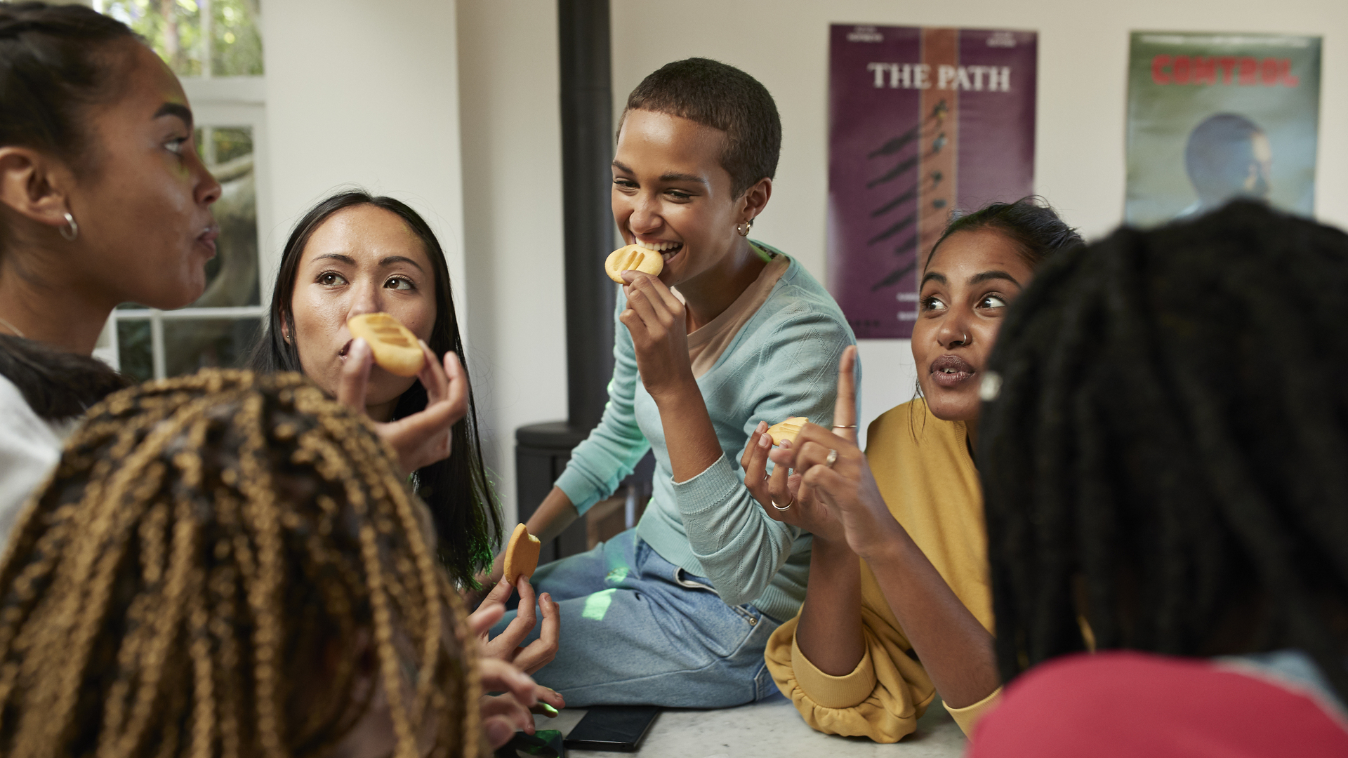 Friends talking while enjoying cookies at home