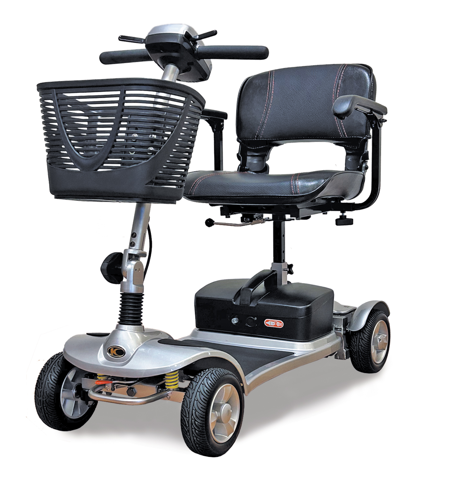 The K-Lite Comfort Ali mobility scooter, shown on a white background, features a compact four-wheel design with a sleek silver finish. It includes a cushioned swivel seat with padded armrests, a tiller with ergonomic handlebars, and a spacious black front basket for storage.