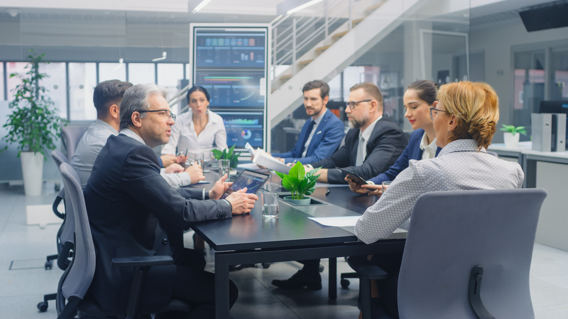 Group of Executives, Lawyers, Businesspeople and Investors Gather at the Table in Corporate Meeting Room to Discuss Business Opportunities, Company Growth Planning and Negotiation Strategy