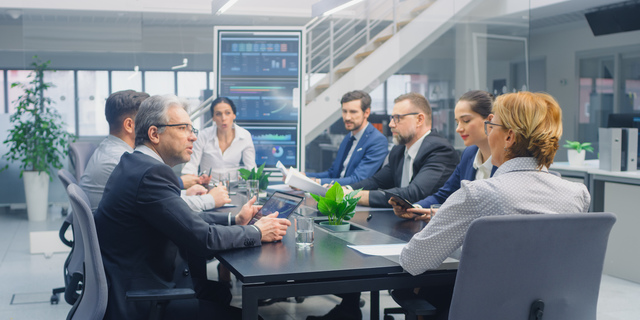 Group of Executives, Lawyers, Businesspeople and Investors Gather at the Table in Corporate Meeting Room to Discuss Business Opportunities, Company Growth Planning and Negotiation Strategy