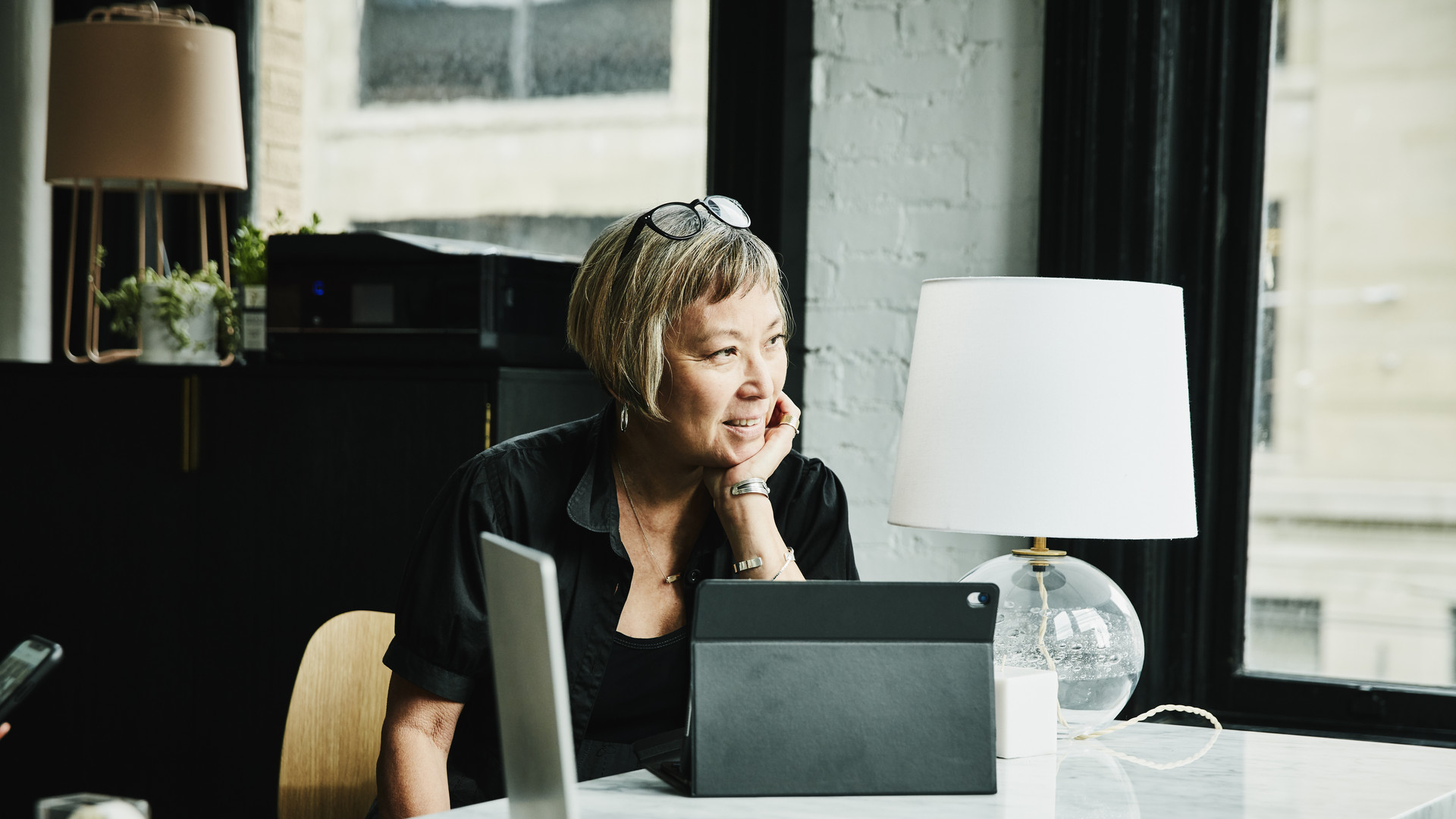 Portrait of smiling mature businesswoman seated at desk in creative office
