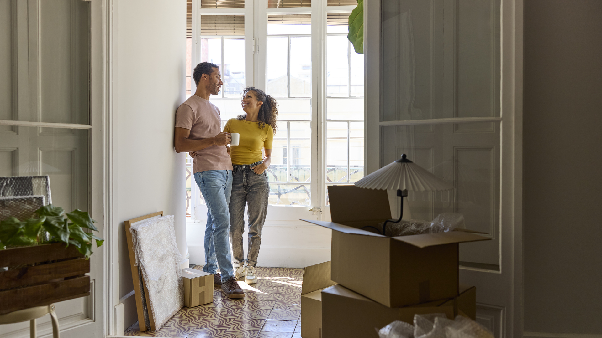 Smiling man and woman talking in balcony at home