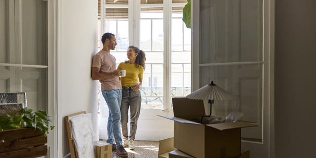 Smiling man and woman talking in balcony at home
