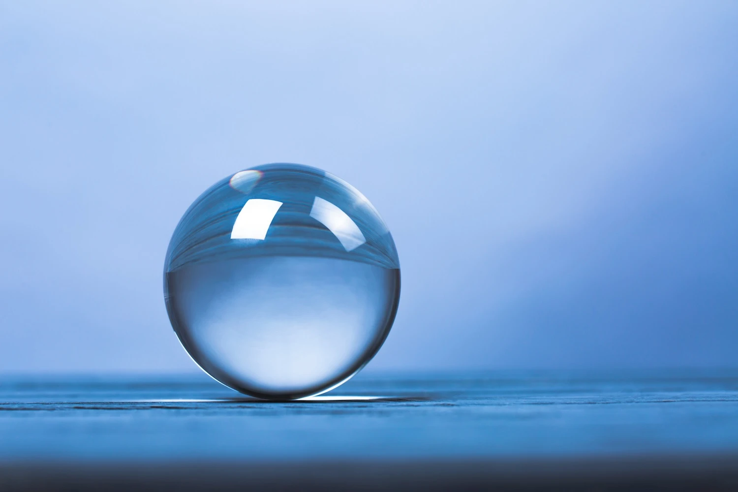 Crystal ball that reflects the surface it sits on - all in blue hues