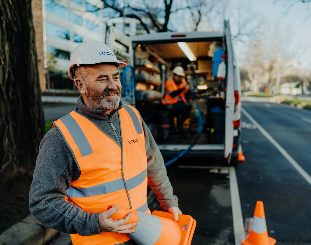 Photo of Vocus Network Worker with hard hat and high vis. Vocus logo on his hard hat