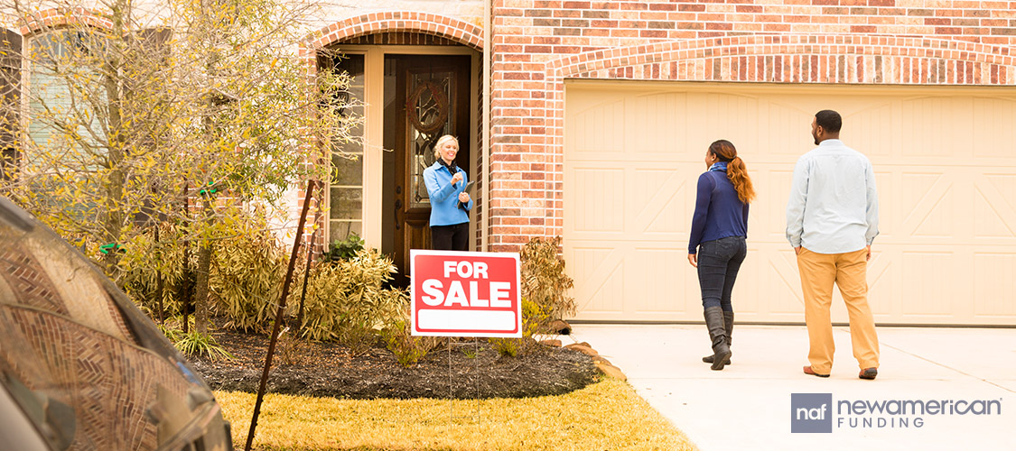 black couple meeting a real estate agent in front a house for sale