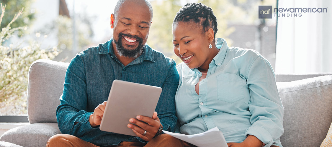 a smiling couple looking at tablet