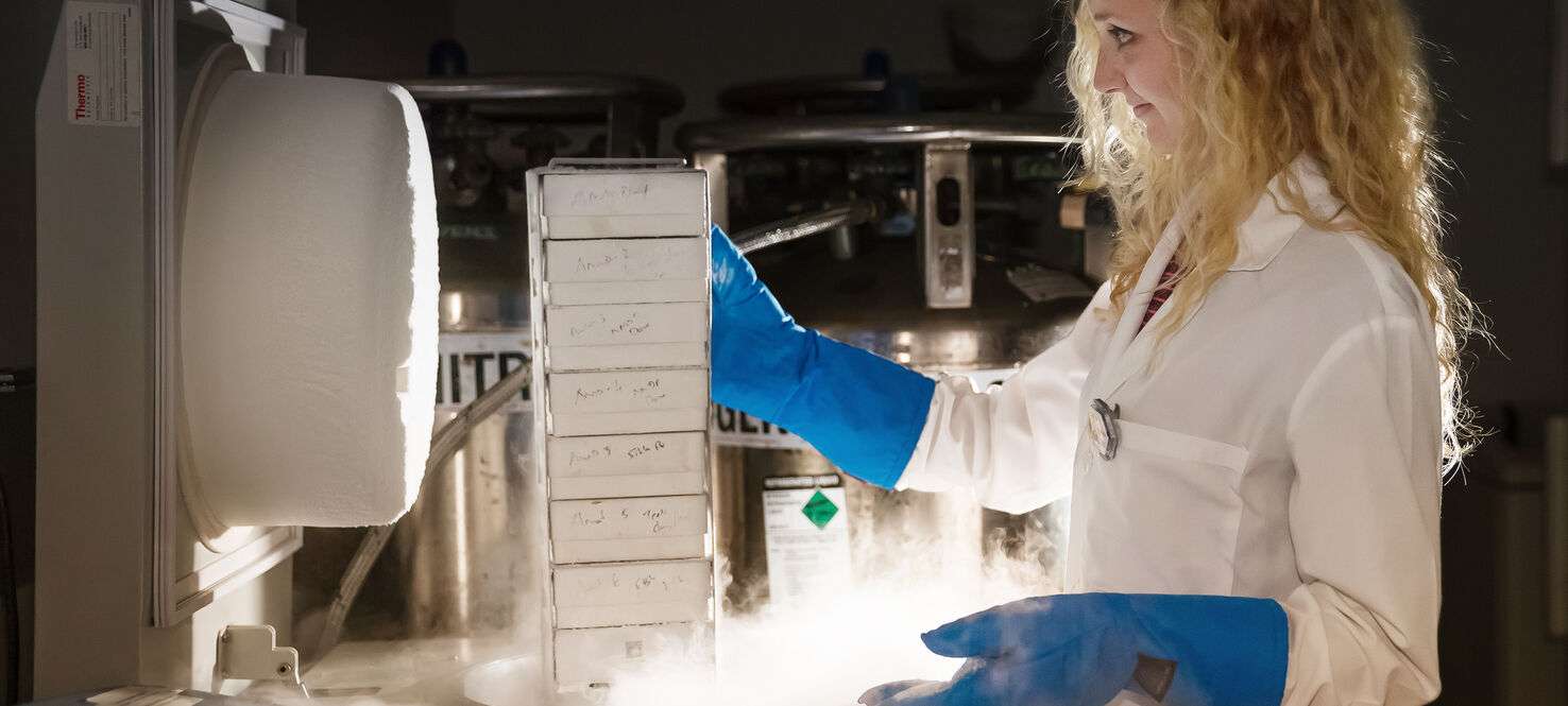 Scientist pulling research specimens from biorepository freezer