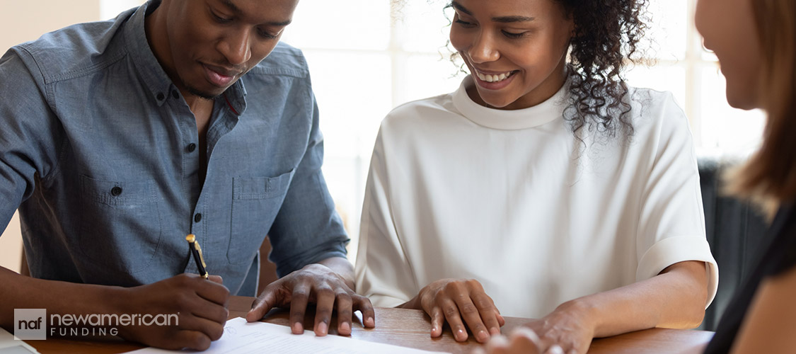 couple signing paperwork with agent