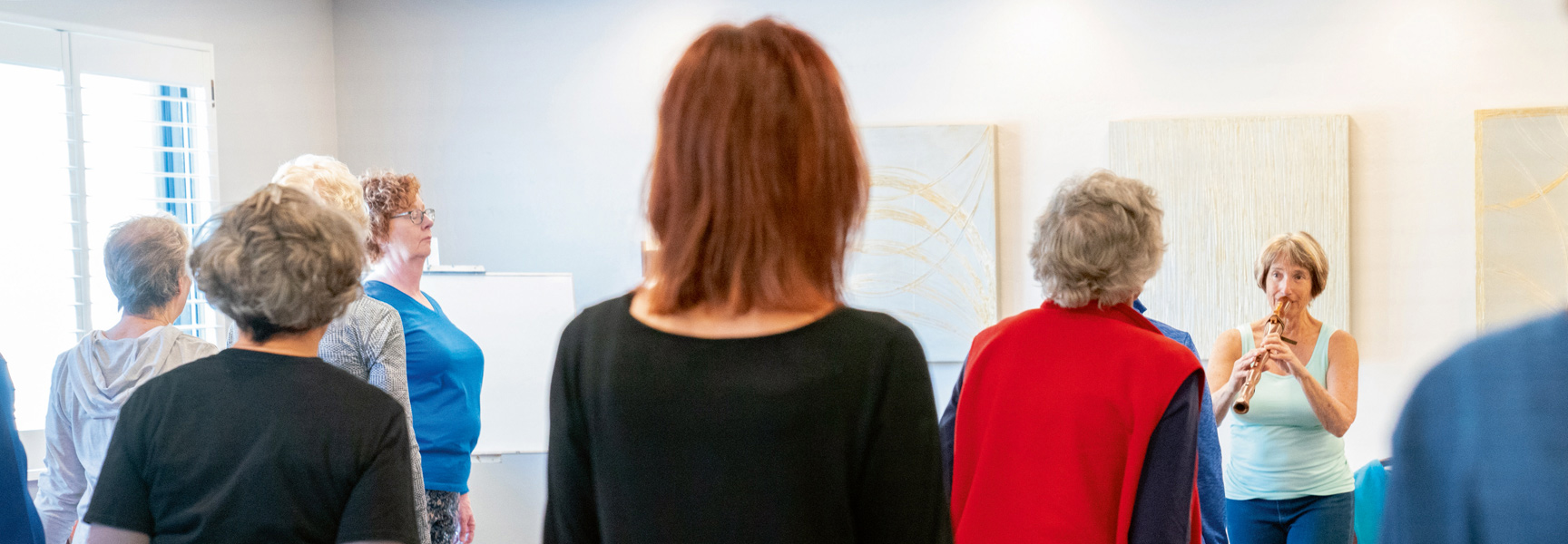 A group of women participate in a healing arts workshop in Arizona, where one woman plays a wooden flute.