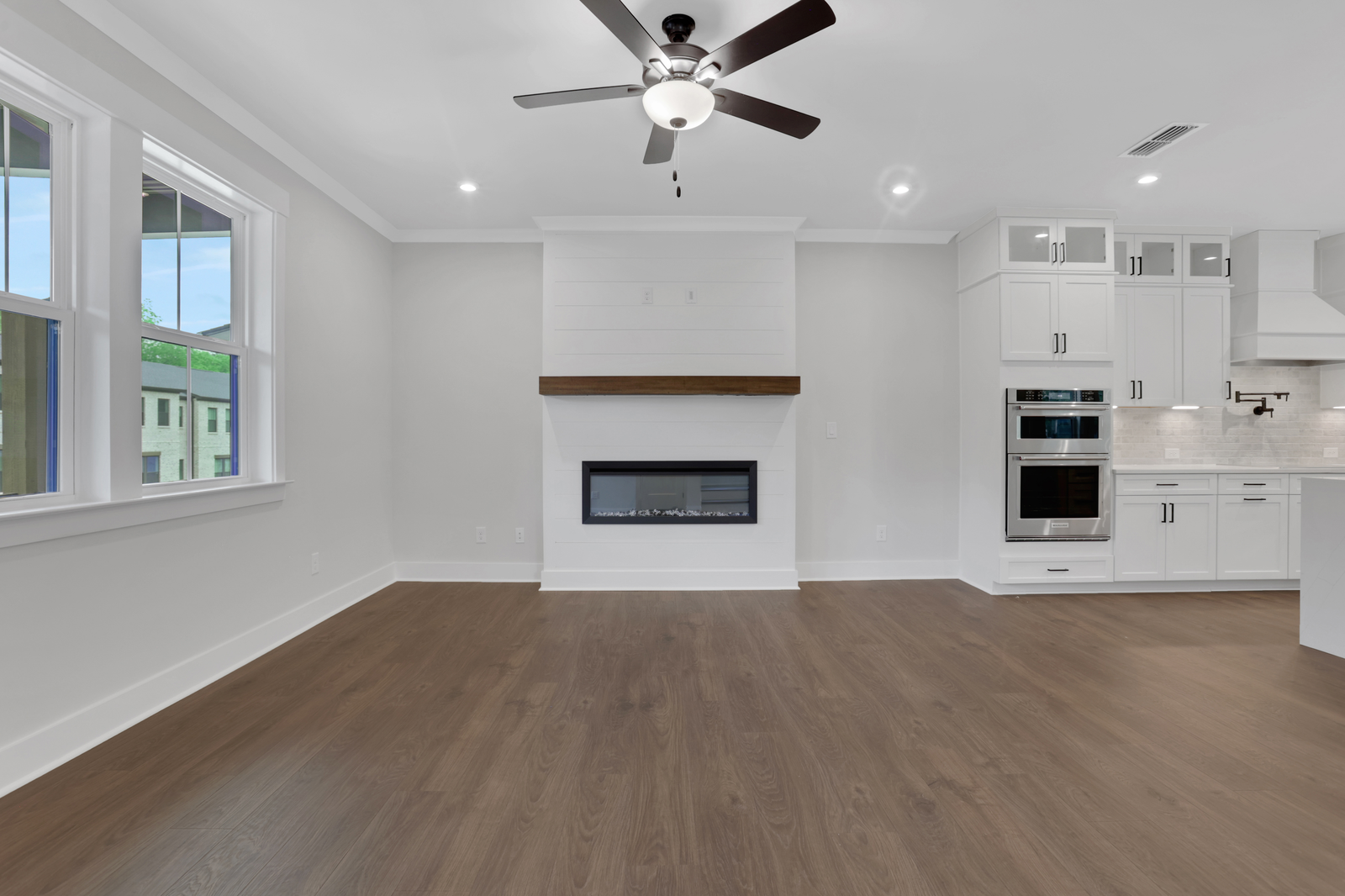 great room with shiplap fireplace and hard surface flooring