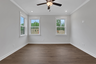 primary bedroom with windows and hard surface floors