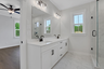 primary bathroom with white cabinets and tile flooring