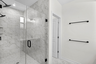walk in shower with tile and black hardware