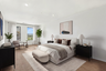 bedroom with hardwood floors windows and queen bed